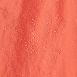 A close up of water droplets on the  surface of the material of a pair of Patagonia Kids Costa Rica Baggies Shorts.