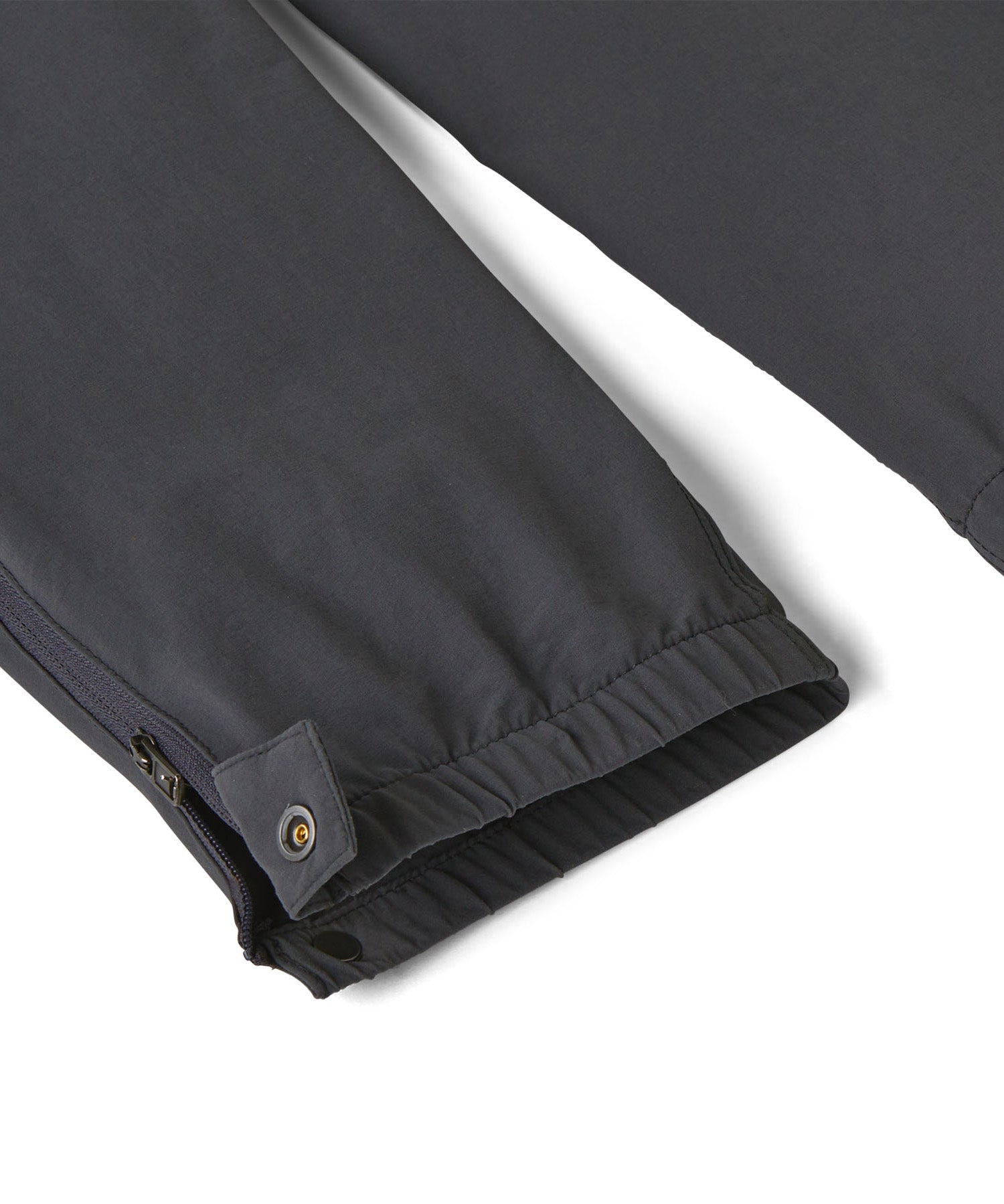 Close up of the elasticated cuff of the Patagonia kids quandry pants. Showing the popper fastener and zip detail for full leg closure.