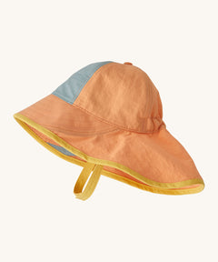 Patagonia kids sun har in a peach colour on a cream background