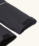 Close up of velcro on the elasticated cuffs of the Patagonia kids waterproof torrentshell 3L rain pants in black.