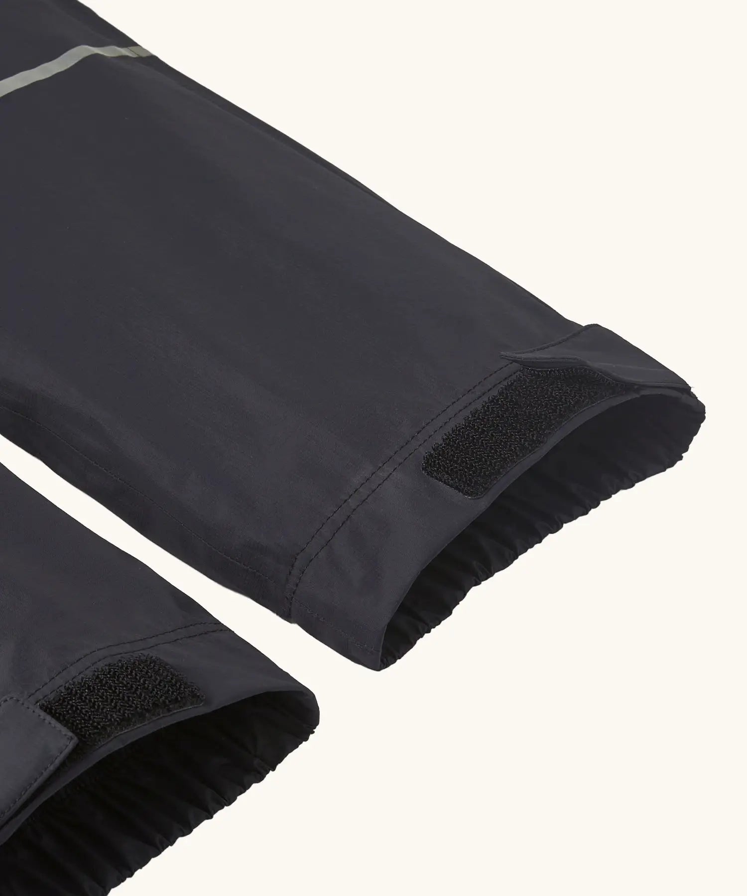 Close up of velcro on the elasticated cuffs of the Patagonia kids waterproof torrentshell 3L rain pants in black.
