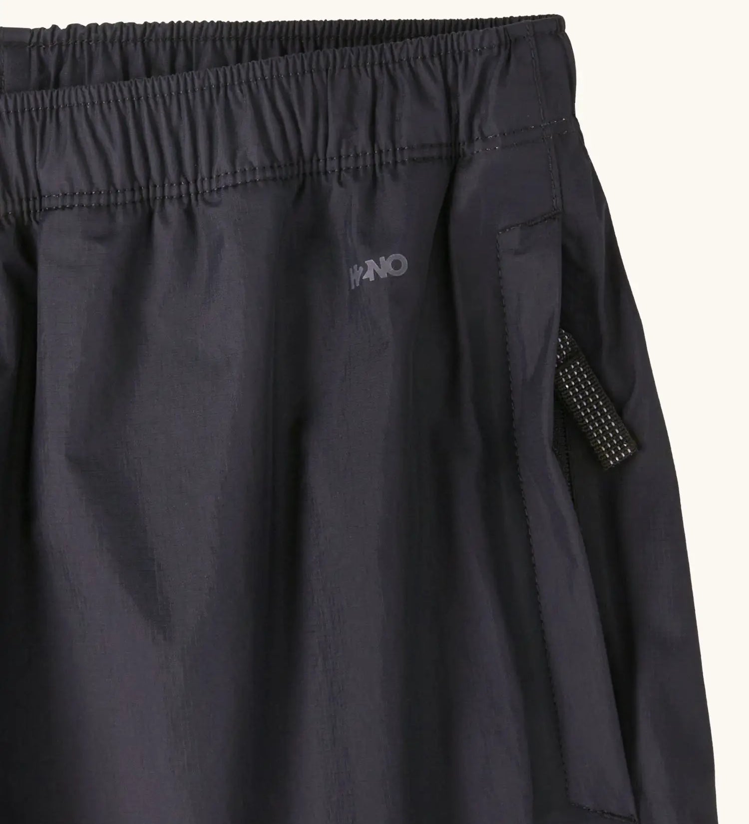 Close up of the zipped hand warmer side pocket on the Patagonia kids waterproof torrentshell 3L rain pants in black.
