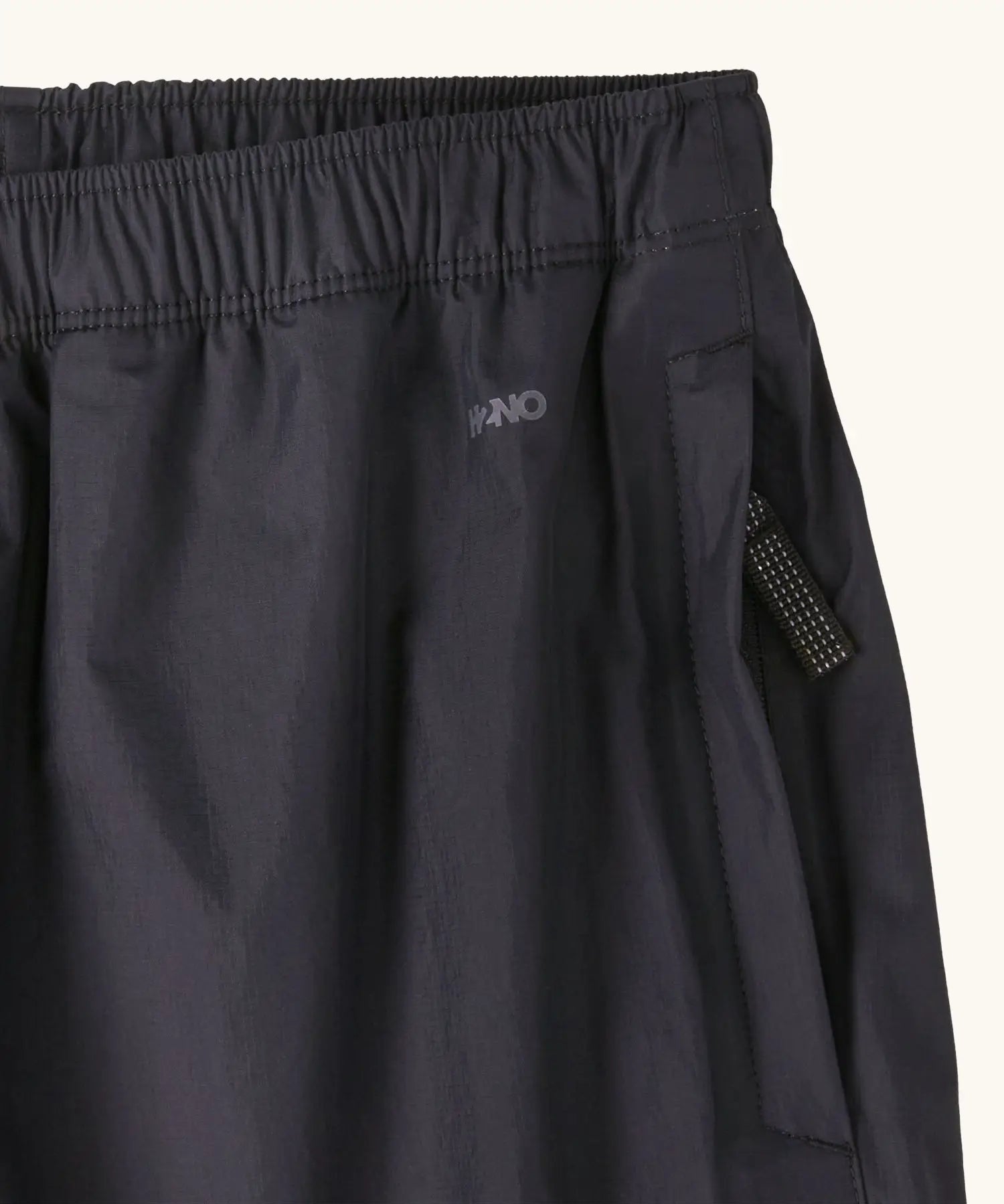 Close up of the zipped hand warmer side pocket on the Patagonia kids waterproof torrentshell 3L rain pants in black.