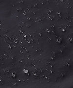 Close up of water droplets formed on the Patagonia kids waterproof torrentshell 3L rain pants in black.