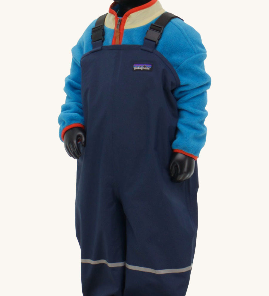 A close up of a mannequin wearing the Patagonia Little Kids Torrentshell 3L Rain Bibs in a New Navy colour.