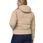 A view of the back of a woman with long light coloured hair wearing the Patagonia Women's Downdrift Jkt Oar Tan
