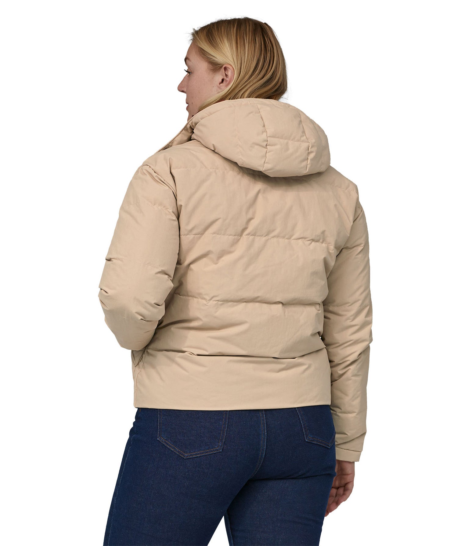 A view of the back of a woman with long light coloured hair wearing the Patagonia Women's Downdrift Jkt Oar Tan