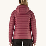 A women wearing the Patagonia Women's Down Insulated Sweater Hoody in a Marion Red colour. She is facing away from the camera showing the back of the jacket. 