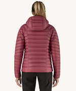 A women wearing the Patagonia Women's Down Insulated Sweater Hoody in a Marion Red colour. She is facing away from the camera showing the back of the jacket. 