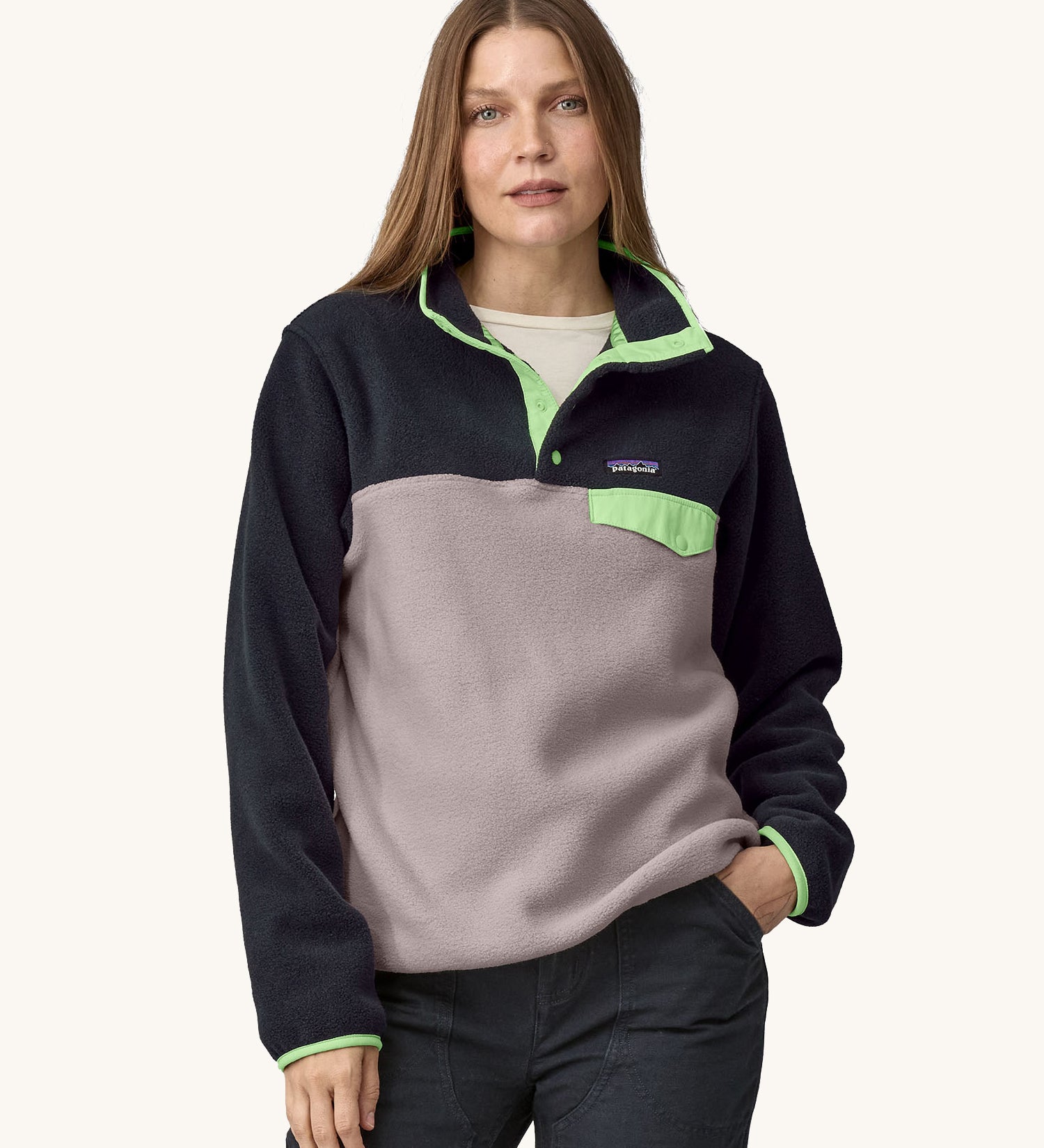 A woman wearing the Patagonia Women's Lightweight Synchilla Snap-T Fleece in an Echo Purple colour.