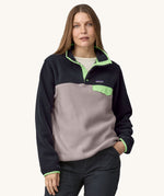 A woman wearing the Patagonia Women's Lightweight Synchilla Snap-T Fleece in an Echo Purple colour.