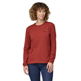 Woman wearing atagonia Long Sleeved Responsibili-Tee in red with a small Patagonia logo on the top right - the lowest carbon footprint t-shirt - made from recycled cotton and post-consumer recycled polyester.