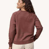 A woman wearing the Patagonia Women's Regenerative Cotton Essential Top in a Dulse Mauve colour. the woman is facing away from the camera showing the back of the top. 
