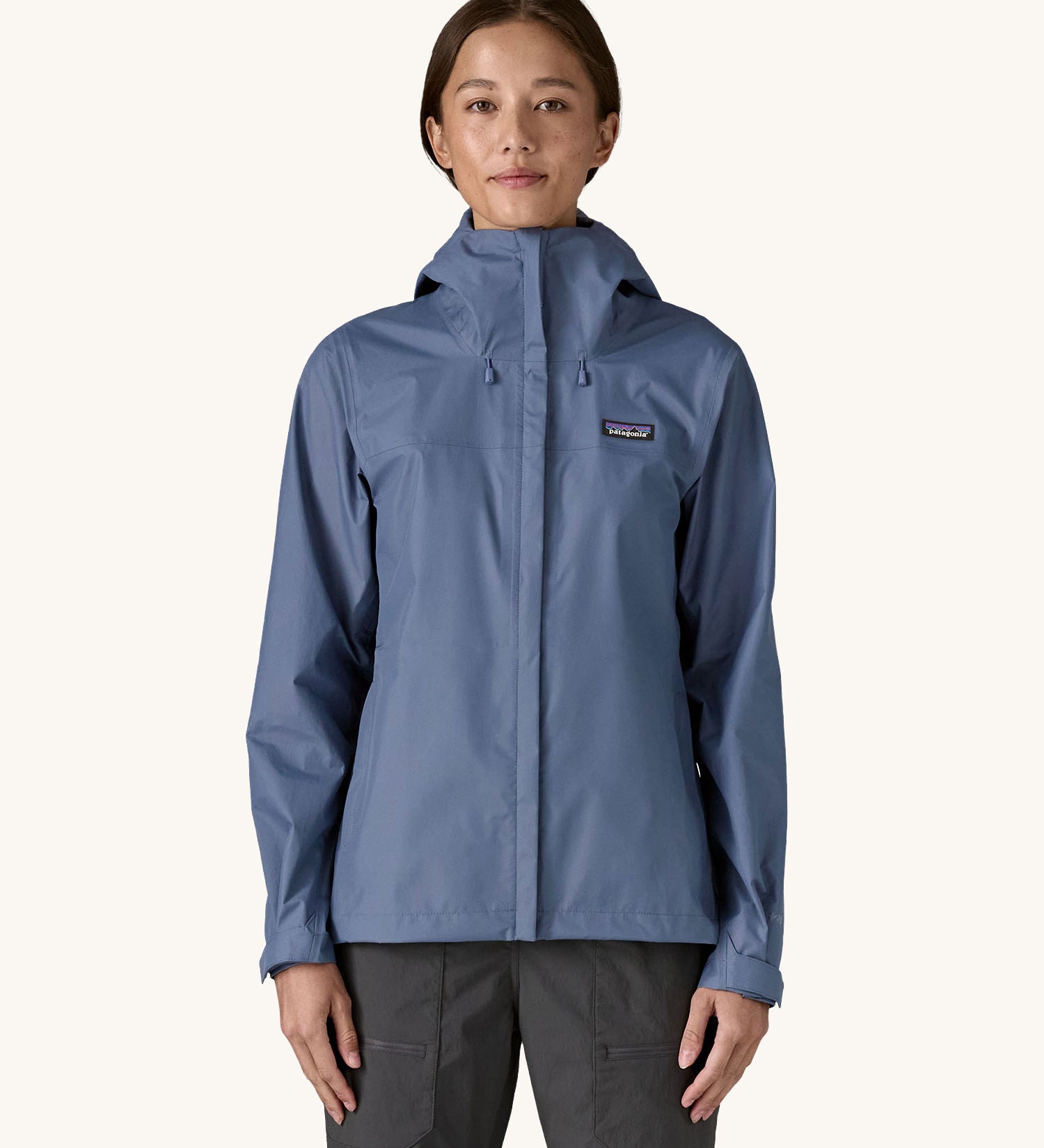A woman wearing the Patagonia Women's Torrentshell 3L Rain Jacket in a Current Blue colour. We have a wide range of Patagonia adult's and children's coats and clothing at Babipur.