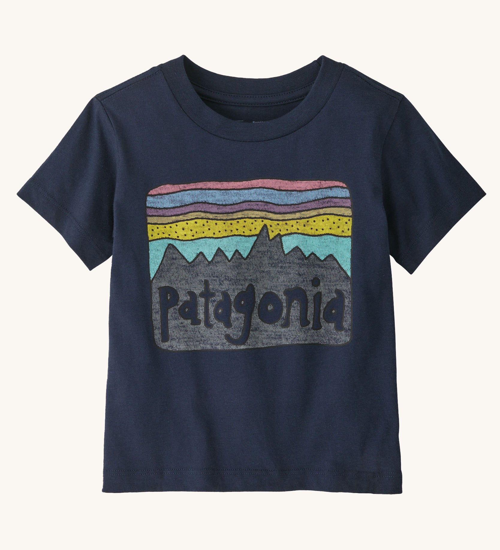 Patagonia Little Kids Fitz Roy Skies T-Shirt - New Navy. A deep, navy blue t-shirt with a fun Patagonia mountain range print in front of a striped pink, blue, purple and .yellow sky