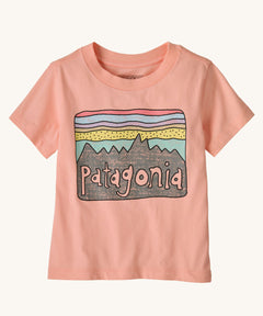 The Patagonia Little Kids Regenerative Fitz Roy Skies T-Shirt in a Sunlit Pink colour way on a plain background.