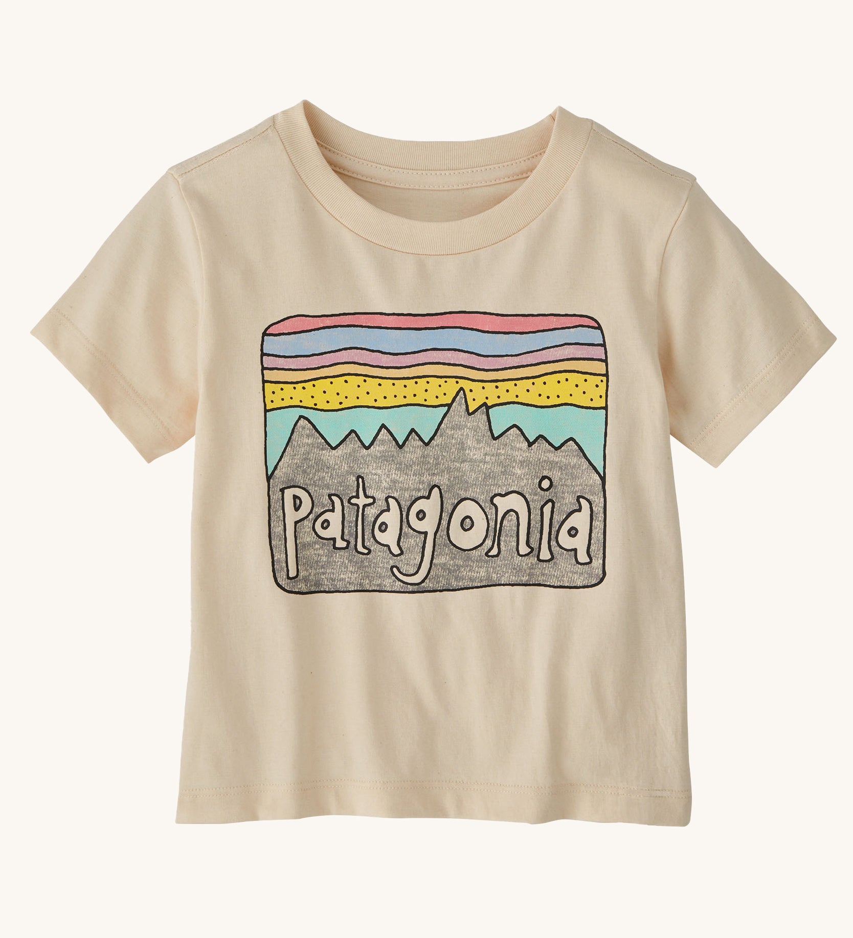 The Patagonia Little Kids Regenerative Fitz Roy Skies T-Shirt in a Undyed Natural colour way on a plain background. 