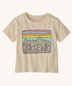 The Patagonia Little Kids Regenerative Fitz Roy Skies T-Shirt in a Undyed Natural colour way on a plain background. 
