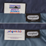 The details on the Patagonia Little Kids Down Sweater ID label. One side has a place to write a name and the other side has the Patagonia mountains emblem along with the words wear it, outgrow it and hand it down written underneath. 