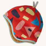 Patagonia little kids in forest being and sizzle red design. A reversible hat which features a red beanie with different coloured shapes and grey decorative tabs on top and brown fur on the inside to keep the head and ears warm. 