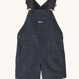 The Patagonia Little Kids Stand Up Shortalls in an Smolder Blue colour on a plain background.