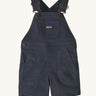 The Patagonia Little Kids Stand Up Shortalls in an Smolder Blue colour on a plain background.
