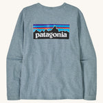 Patagonia thermal blue long sleeve top on a cream background.