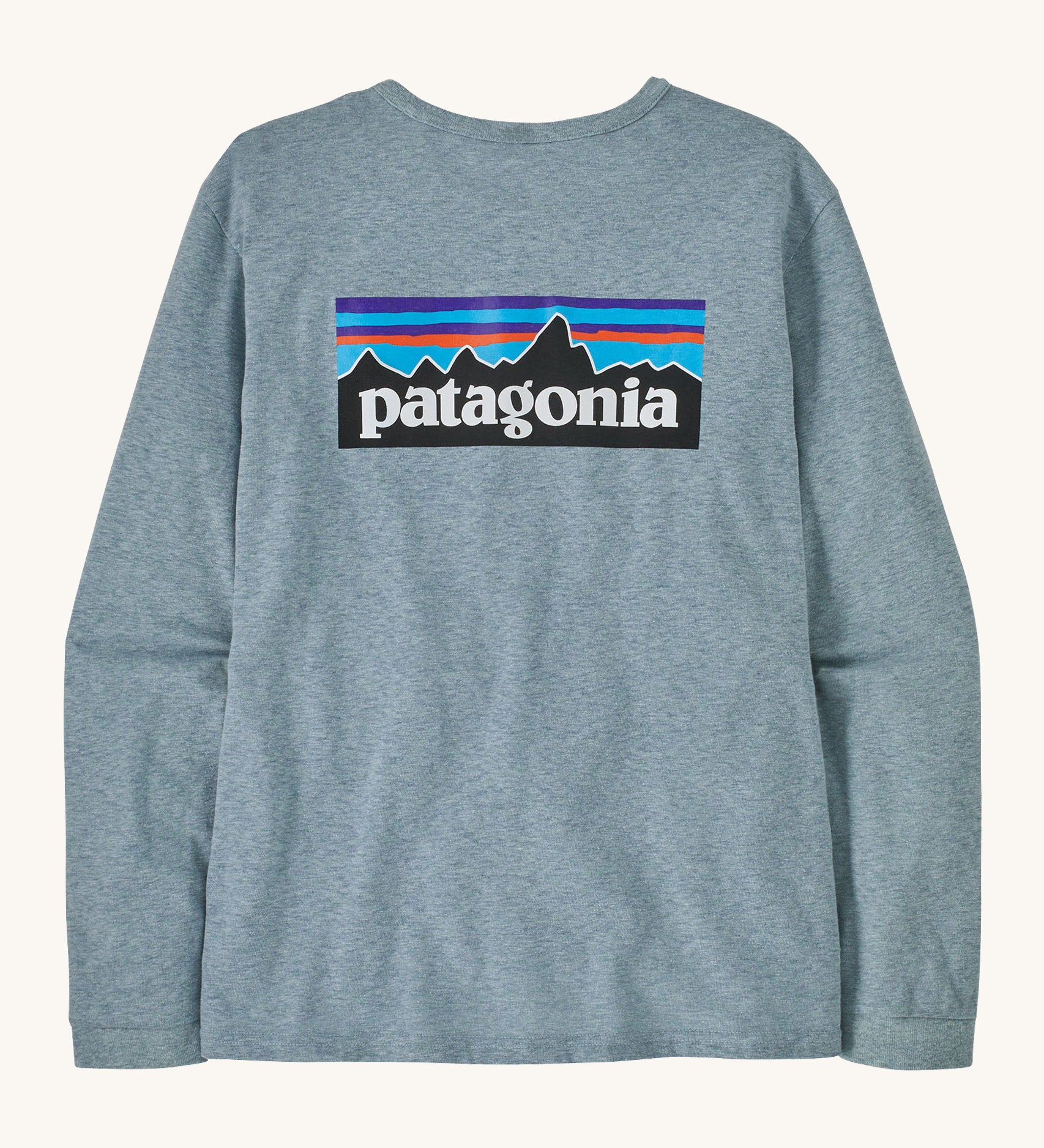 Patagonia thermal blue long sleeve top on a cream background.