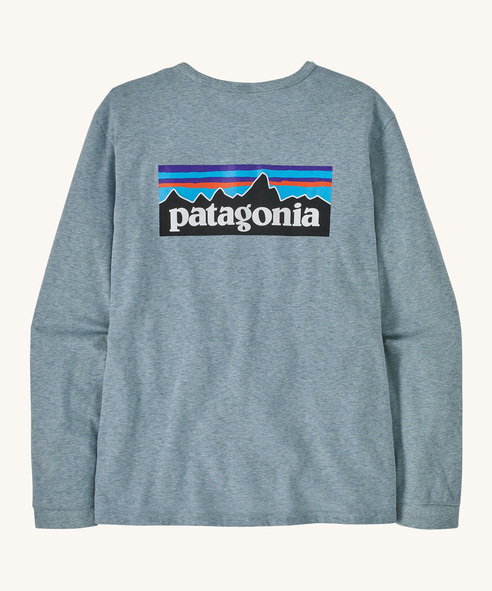 Patagonia thermal blue long sleeve top on a cream background.