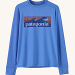 Patagonia kids long sleeve tshirt in a light blue colour with logo on a cream background.