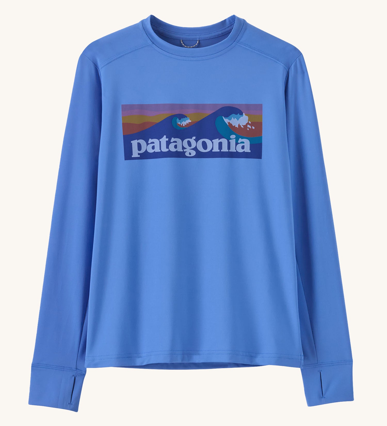 Patagonia kids long sleeve tshirt in a light blue colour with logo on a cream background.