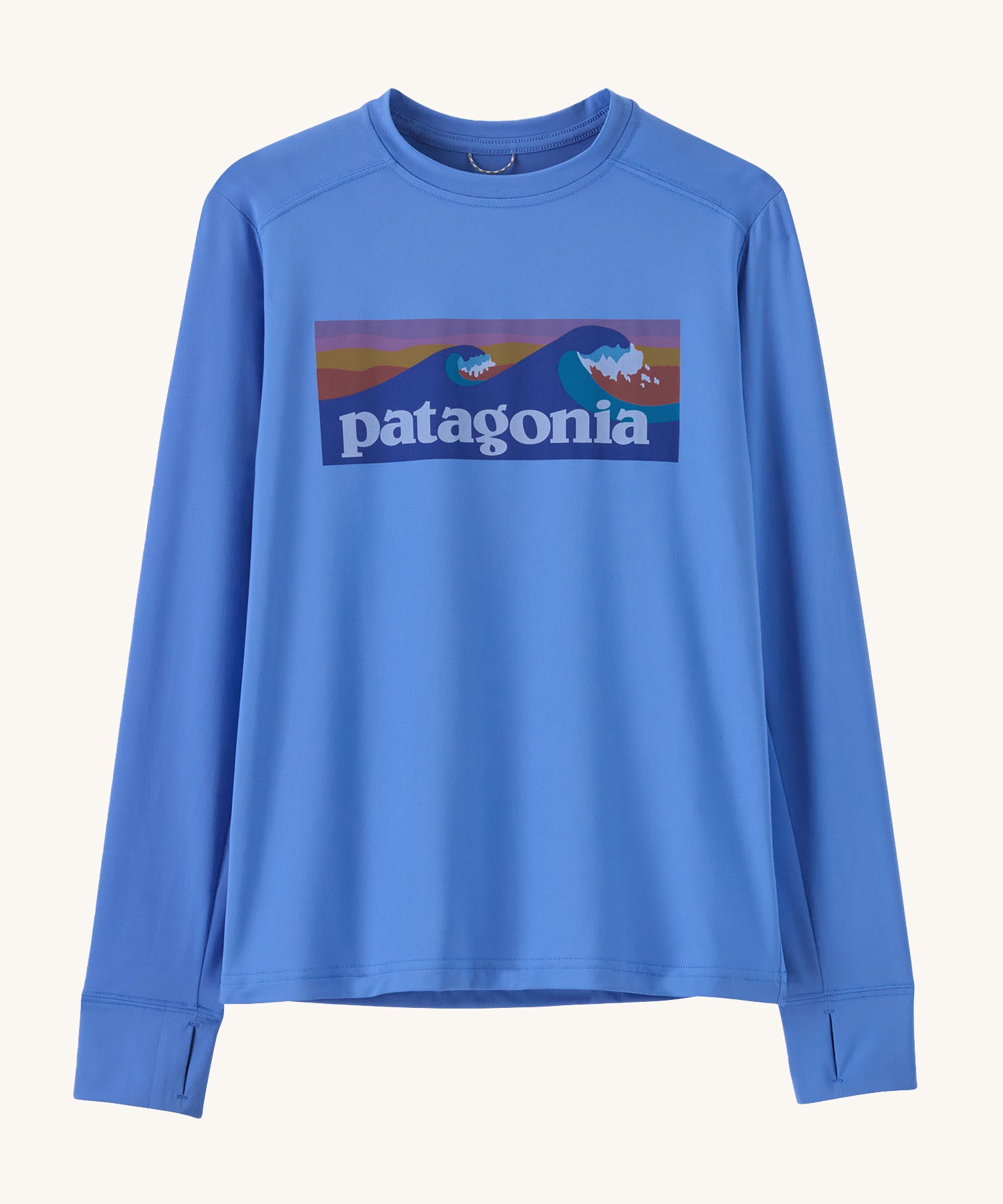 Patagonia kids long sleeve tshirt in a light blue colour with logo on a cream background.
