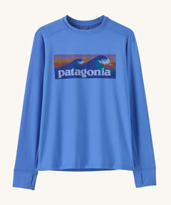 Patagonia kids long sleeve tshirt in a light blue colour with logo on a cream background.