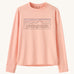 Patagonia kids long sleeve tshirt in a light pink colour with logo outline on a cream background.