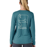 Patagonia women's long sleeve capilene top in turquoise beach outline design worn by a woman