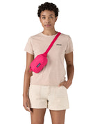 Patagonia Terravia Mini Hip Pack in a  luminous pink colour worn by an adult on the shoulder