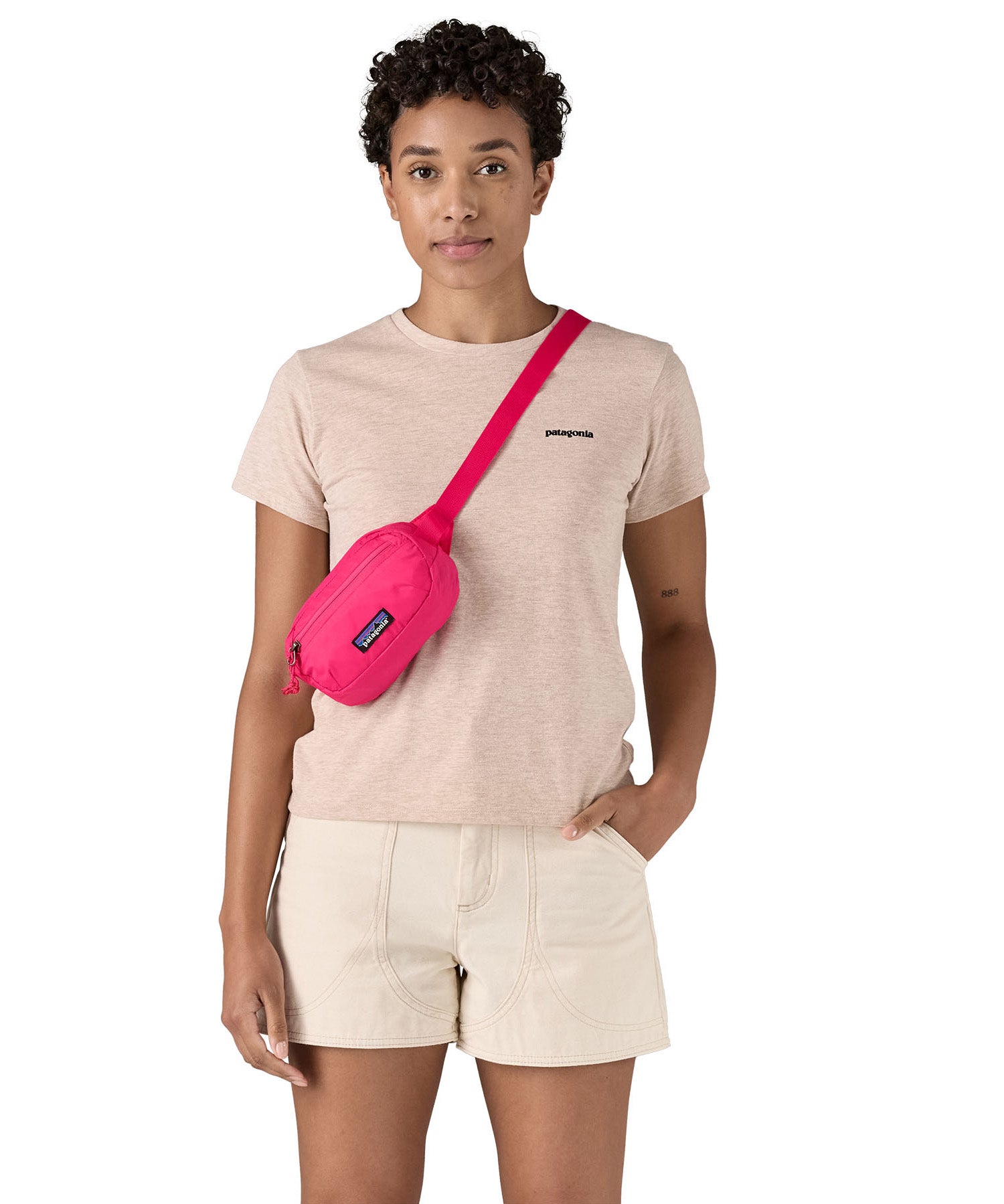 Patagonia Terravia Mini Hip Pack in a  luminous pink colour worn by an adult on the shoulder