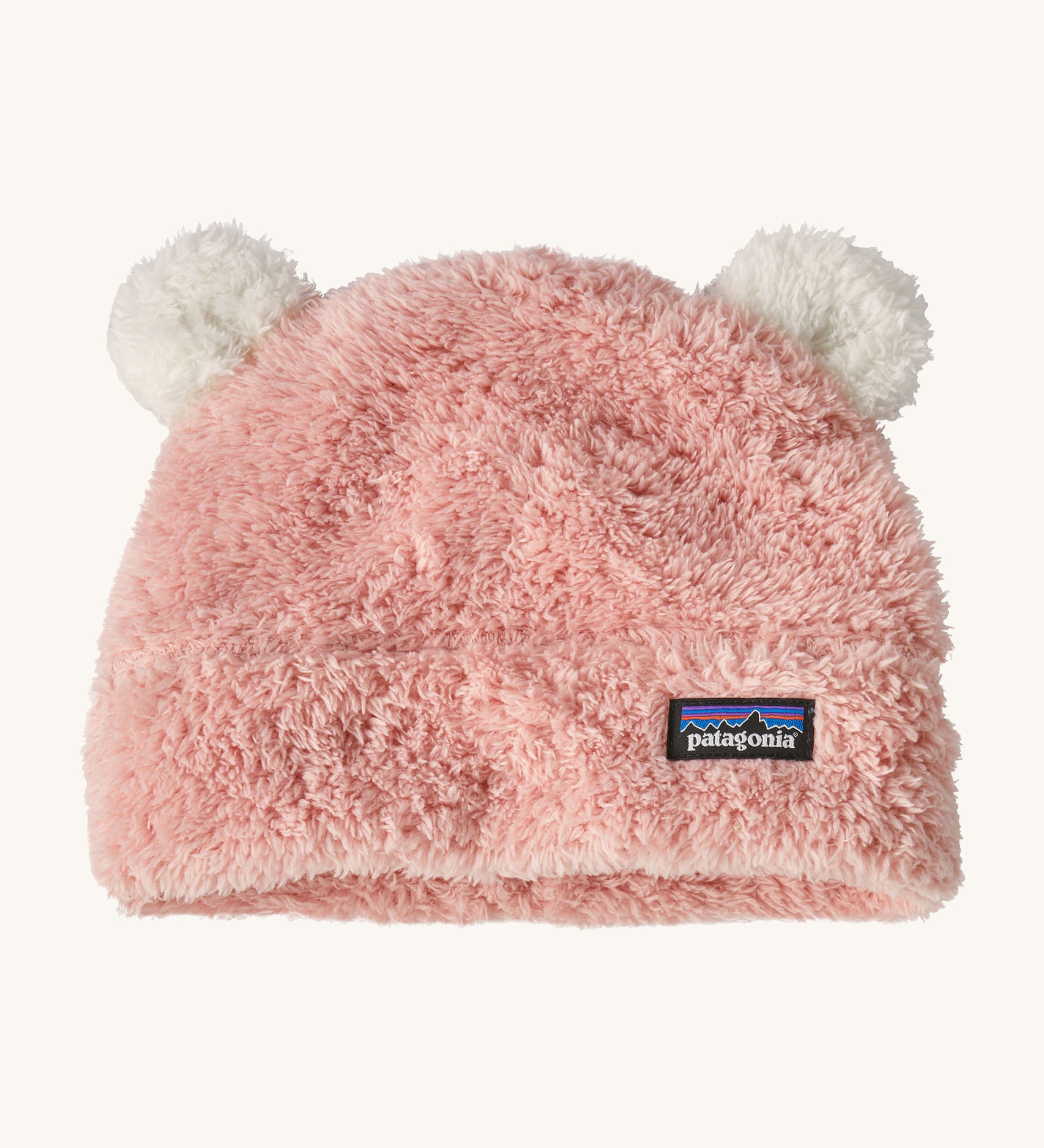 Patagonia little kids friends hat. A pink furry beanie to keep the head warm which features white bear-like ears on the top of the beanie. Features the logo patch stitched on the front side of the hat.