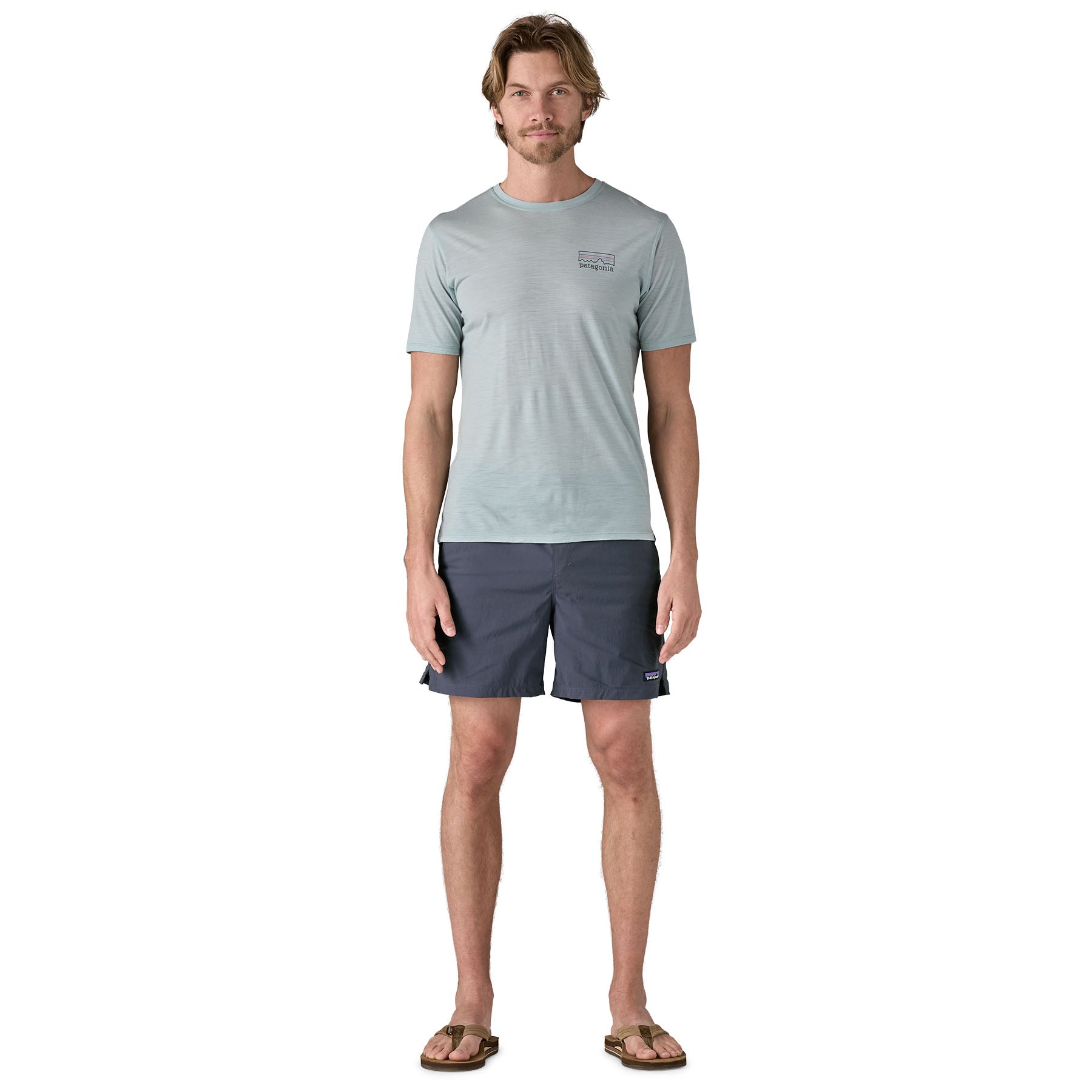 A man wearing a t-shirt and The Patagonia Men's baggies 6 inch beach shorts in smolder blue
