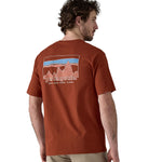 A man waering teh Patagonia Men's 73 Skyline Organic T-Shirt Burnished Red showing the back of the top