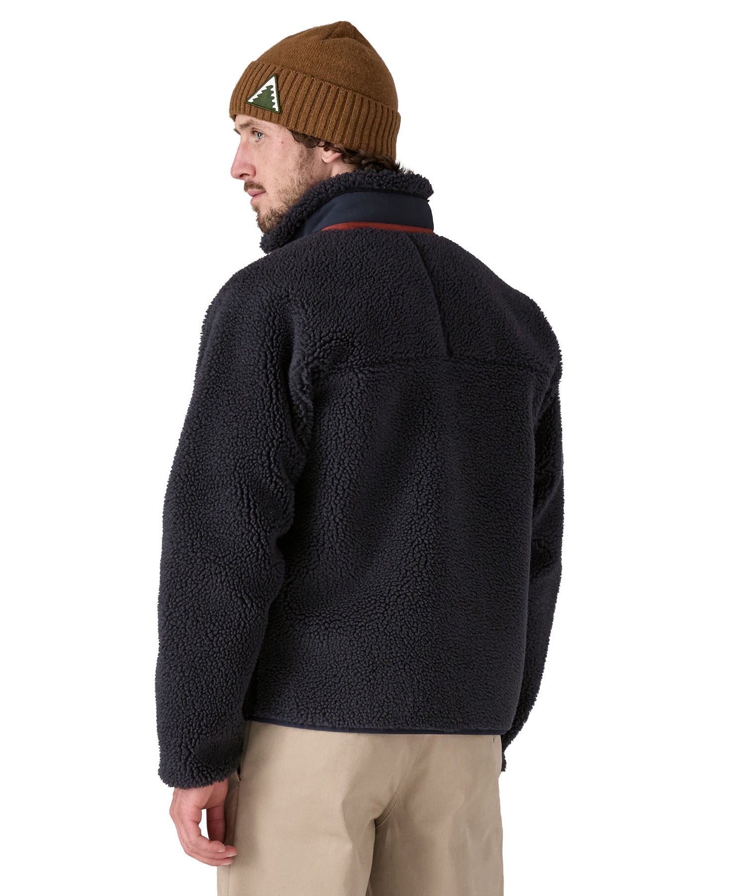 A man wearing a Patagonia Men's Classic Retro-X Jacket in a dark smolder blue colour, facing away from the camera, showing the back of the jacket..