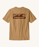 Patagonia men's boardshort logo top in talon gold. A pale gold colour t-shirt with short sleeve with a large branded print on the back. 