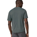 A man wearing a Patagonia Men's Cap Cool Daily Graphic Shirt in Nouveau Green showing the back of the t-shirt