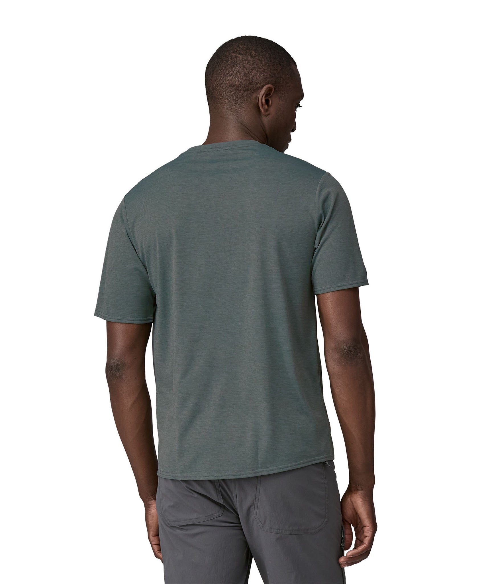 A man wearing a Patagonia Men's Cap Cool Daily Graphic Shirt in Nouveau Green showing the back of the t-shirt