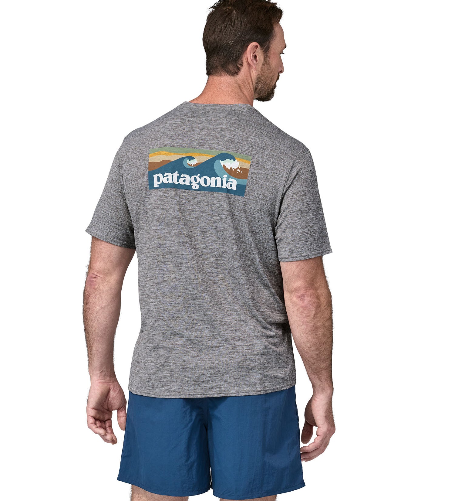 A man wearing a Patagonia Men's Capilene Cool Daily Graphic Shirt with a Waters / Feather Grey design, the man is facing away from the camera showing the back of the t-shirt. 