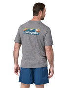 A man wearing a Patagonia Men's Capilene Cool Daily Graphic Shirt with a Waters / Feather Grey design, the man is facing away from the camera showing the back of the t-shirt. 