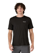 Man wearing a Patagonia men's Capilene merino blend black, loose fit graphic short sleeved t-shirt with white logo on the chest.