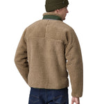 A man wearing a Patagonia Men's Classic Retro-X Jacket in a Seabird Grey colour and a green beanie hat facing away from the camera showing the back of the jacket. 