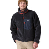 A man wearing a Patagonia Men's Classic Retro-X Jacket in a dark smolder blue colour.  