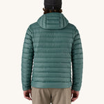 A man wearing the Patagonia Men's Down Sweater Hoody Jacket in a Wetland Blue colour. He is facing away from the camera showing the back of the jacket. 